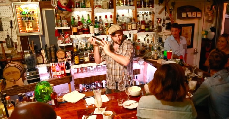 Joe Brooke shakes up a cocktail in his "Barage" bar in his backyard.