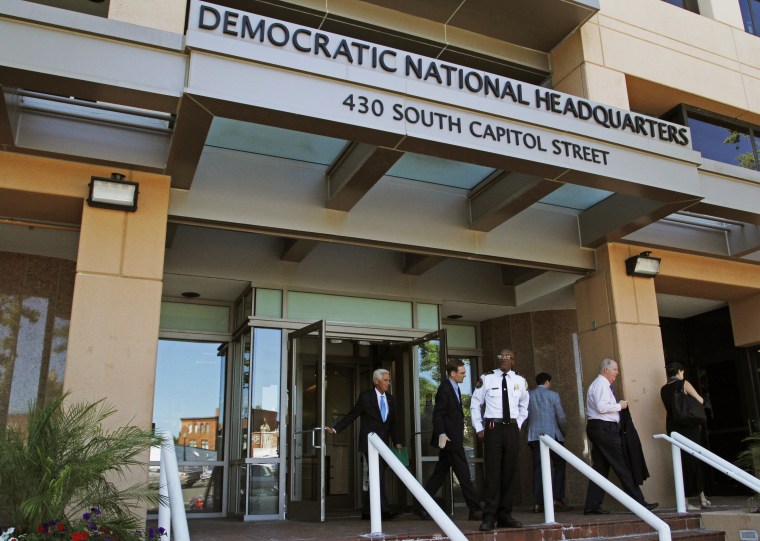 People stand outside the Democratic National Committee (DNC) headquarters in Washington, Tuesday, June 14, 2016. Two ???sophisticated adversaries??? linked to Russian intelligence services broke into the Democratic National Committee???s computer networks and gained access to confidential emails, chats and opposition research on presumptive Republican nominee Donald Trump, the party and an outside analyst said Tuesday, June 14, 2016. (AP Photo/Paul Holston)