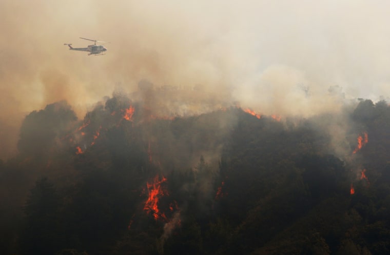 Image: A Cal Fire helicopter flies over Williams Canyon during the Soberanes Fire near Carmel Valley