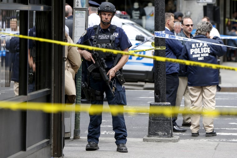 Image: Members of the NYPD police stand near the crime scene at the intersection of 37th street and 8th avenue in midtown Manhattan in New York