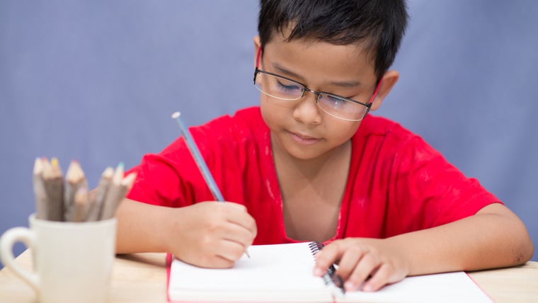 boy writing in notebook