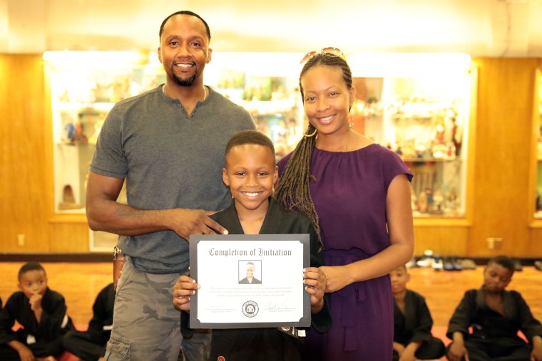 Bruce Collins III, with his parents after passing his initiation test.