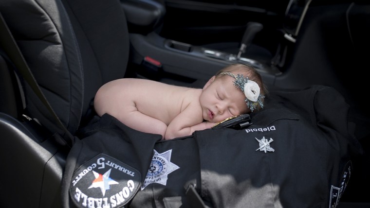 baby swaddled with police badge