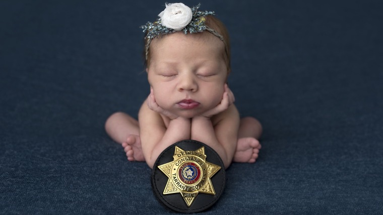 baby swaddled with police badge