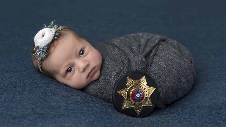 baby swaddled with police badge