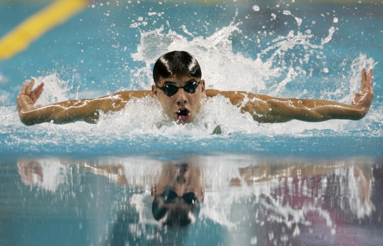 Syria's Anys swims to win his heat during the men's 100m butterfly swimming heats at the 15th Asian Games in Doha