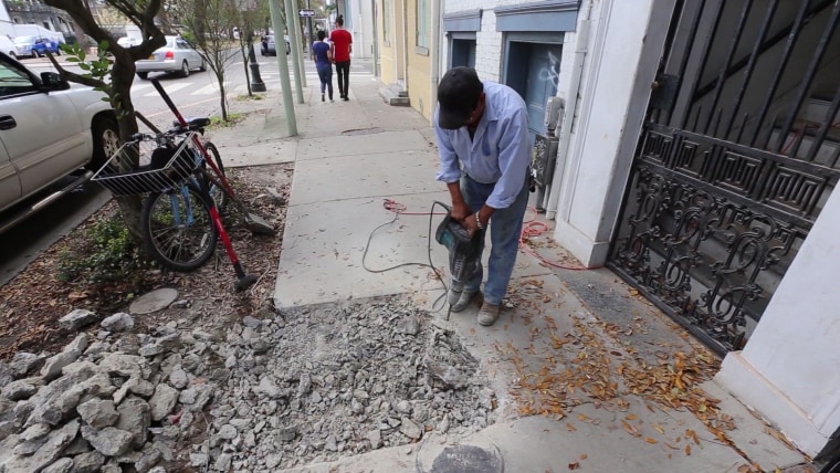 Searching for a lead pipe, a construction worker hammers into the sidewalk on New Orleans' Esplanade Avenue, lined with some of New Orleans' oldest homes. Older cities and properties built before 1950 are more likely to have lead service lines, which connect water mains to homes.
