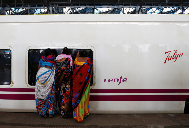 Image: People look inside the parked high speed Talgo train during its trial run at a railway station in Mumbai