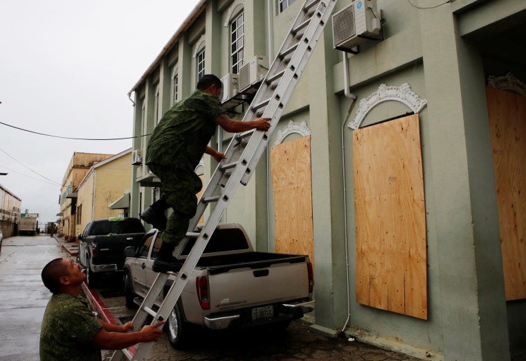 Image: Soldiers cover the windows of Belize City's town hall, as Hurricane Earl approaches,in Beilize City