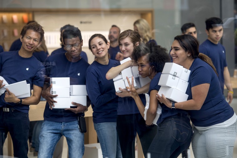 A female customer carries an Apple shopping bag at an Apple retail