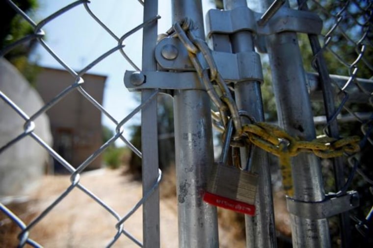 A lock secures a chain on the steel fence of a foreclosed home previously owned by U.S. Bancorp in Los Angeles