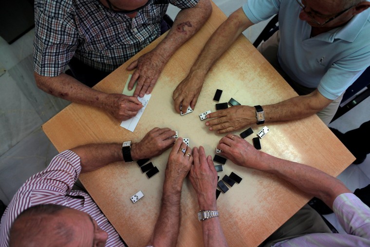 Image: Pensioners play dominoes at "Anica Torres" seniors centre in Benalmadena