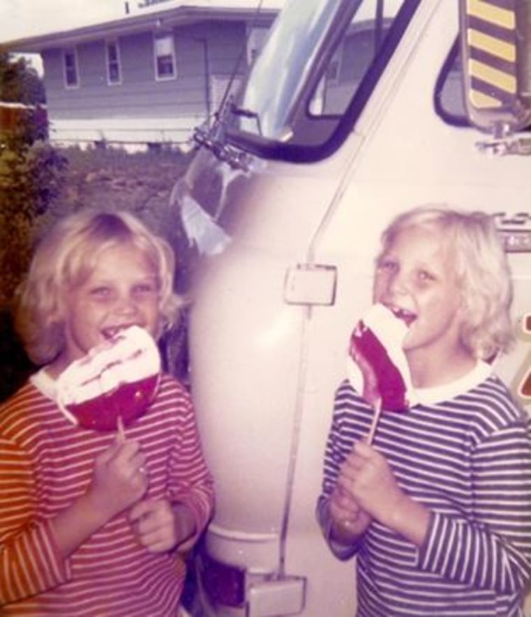 Terry (left) and Sherry (right) standing in front of their grandfather's business van as young girls.