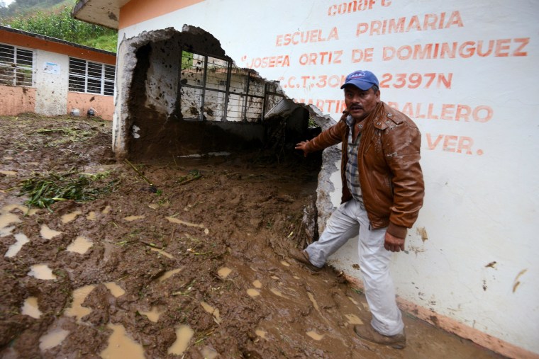 Image: Resident shows a classroom damaged by a mudslide following heavy showers caused by the passing of Tropical Storm Earl, in the town of Temazolapa