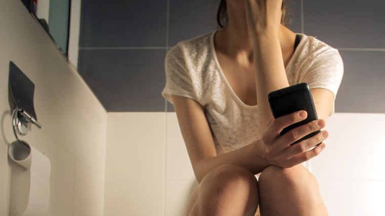 Woman on toilet texting