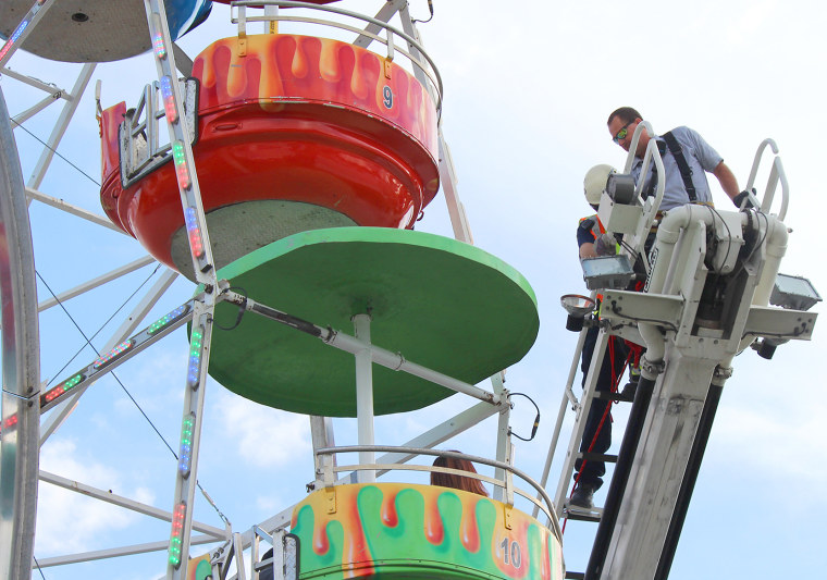 Image: Members of the Greeneville Fire Department help people off the ferris wheel at the Greene County Fair