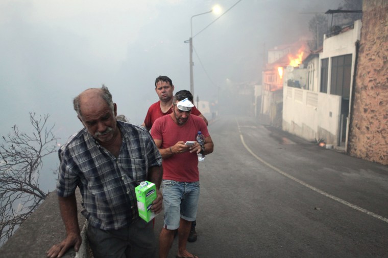 Image: People on the streets of Bom Sucesso, near to a fire during the wildfires at Funchal, Madeira island