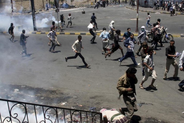 Anti-Houthi protesters seek refuge as pro-Houthi police troopers use tear gas to disperse them in Taiz