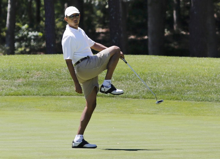 Image: U.S. President Obama reacts after missing putt on the first green at golf on Marthas Vineyard
