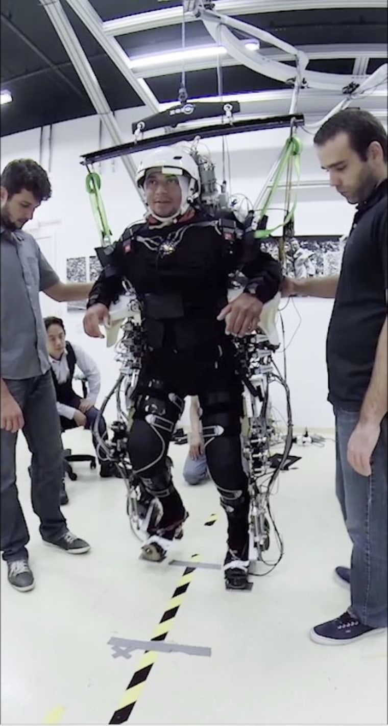 Patient in a training session using harnesses and assistance to learn to regain control of their legs.