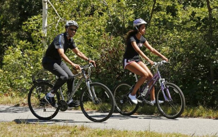 U.S. President Obama cycles with his daughter Malia during their family vacation at Martha's Vineyard in Massachusetts