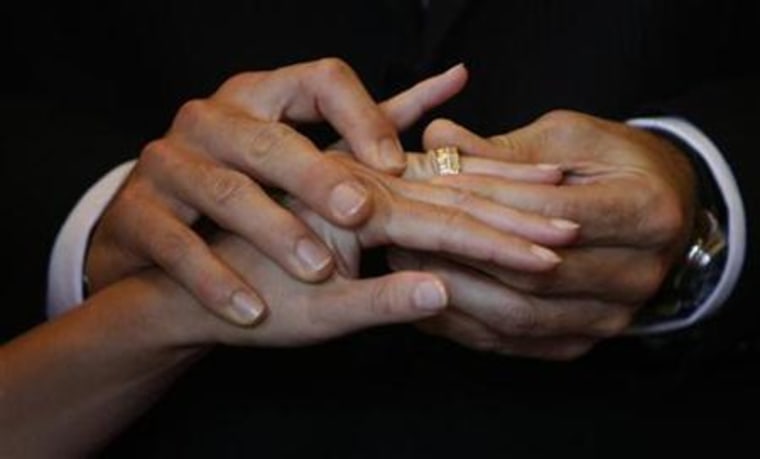 Swiss groom puts a wedding ring on his bride during their wedding ceremony in the traditional City Hall in Lucerne