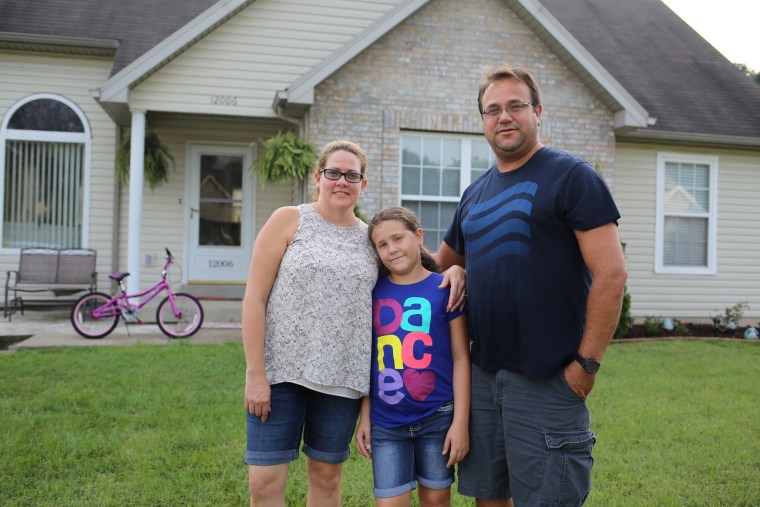 Juan Carlos Labaut and his family stand in front of their home on the outskirts of Louisville.