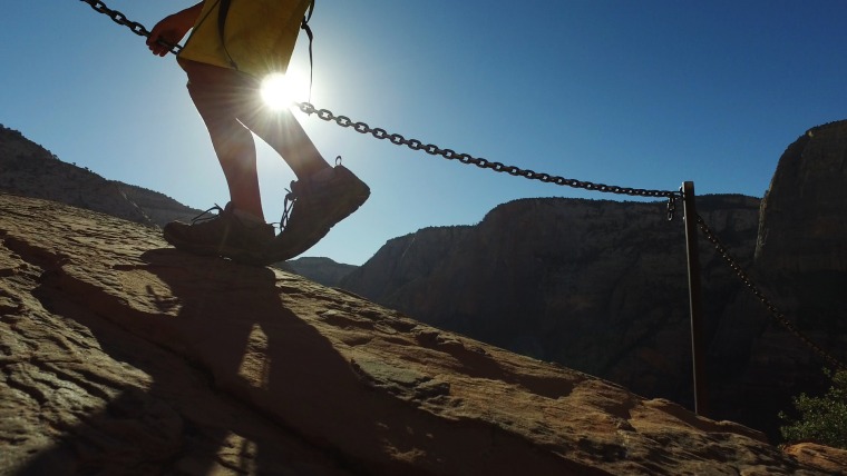 Image: A hiker climbs along the Angels Landing trail in Zion National Park