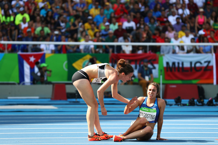 Image: Abbey D'Agostino of the United States (R) is assisted by Nikki Hamblin of New Zealand