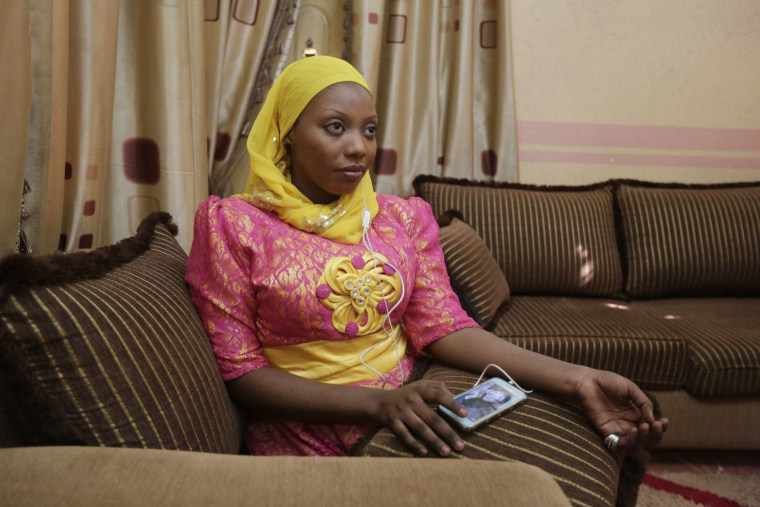In this photo taken Tuesday April, 5. 2016, Khadija Gudaji, a Physics student of Northwest University listen to daily radio talk show on her mobile phone in Kano, Nigeria. In the local market stalls are signs of a feminist revolution with piles of poorly printed books by women, as part of a flourishing literary movement centered in the ancient city of Kano, that advocate against conservative Muslim traditions such as child marriage and quick divorces.  dozens of young women are rebelling through romance novels, many hand-written in the Hausa language, and the romances now run into thousands of titles.