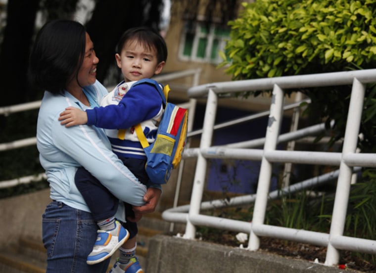 Susan Famadula holds Ka-hei, 3, the child of her employers whom she is hired to look after, in Hong Kong