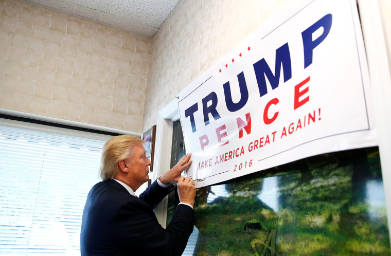 Image: Republican U.S. presidential nominee Donald Trump signs a poster during a visit to Allegra Print and Imaging in Fayetteville