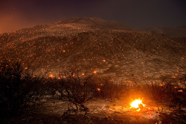 Image: Embers from a wildfire smolder along Lytle Creek Road near Keenbrook, Calif., on Aug. 17.