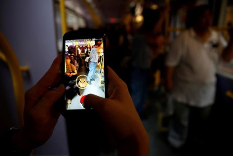 A passenger plays the augmented reality mobile game "Pokemon Go" by Nintendo inside a bus in Hong Kong, China