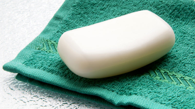 White soap bar on green washcloth