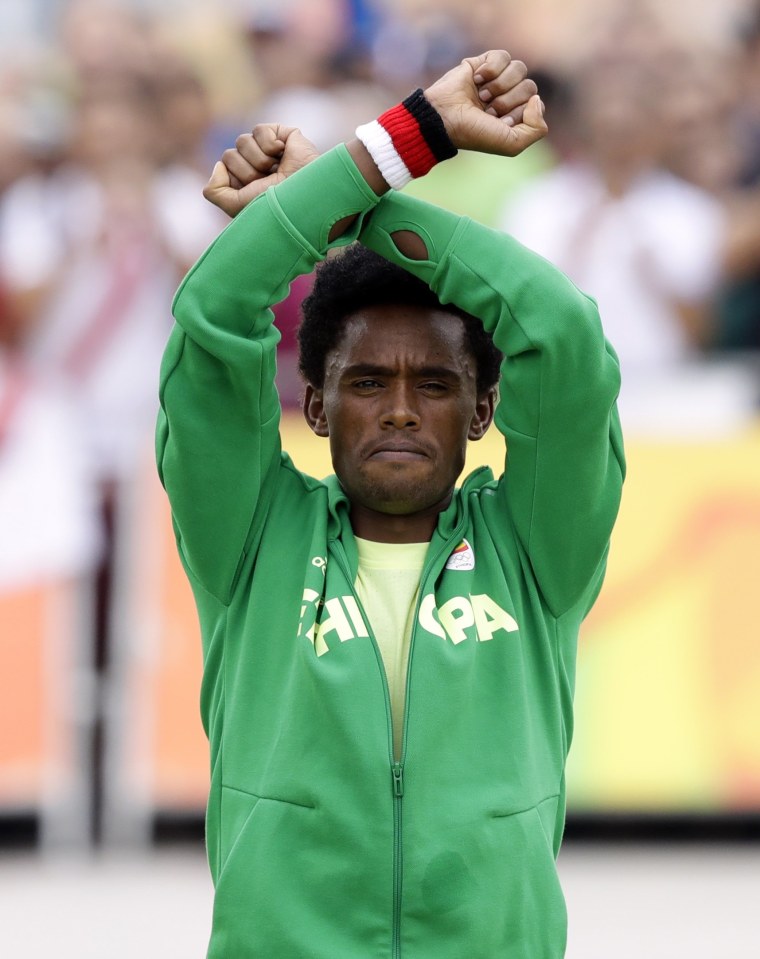 Image: Silver medalist Feyisa Lilesa repeats his 'X' gesture at the medal ceremony in Rio late Sunday.