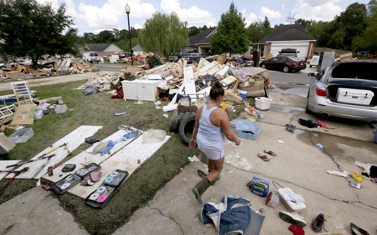 Image: Sheryl Howard walks through her flood damaged frontyard at the South Point subdivision in Denham Springs