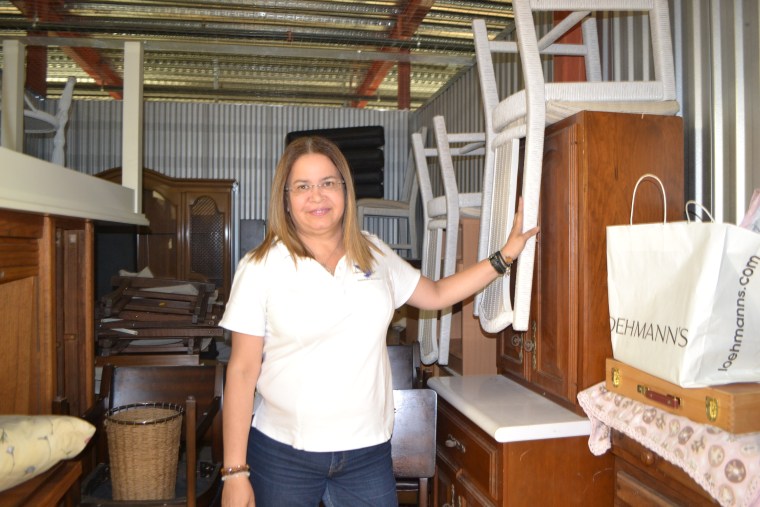Patricia Andrade shows furniture in one of the storage spaces for Raices Venezolanas or Venezuelan Roots