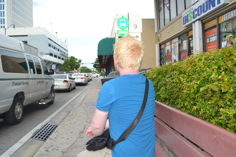 Carlos, a Venezuelan who arrived in Miami in late June, waits for a bus on 8th Street (Calle Ocho) in Miami.