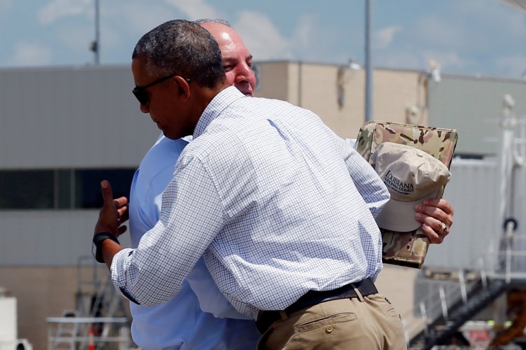 Image: U.S. President Barack Obama embraces Louisiana Governor John Bel Edwards as he arrives aboard Air Force One at Baton Rouge Metropolitan Airport in Baton Rouge