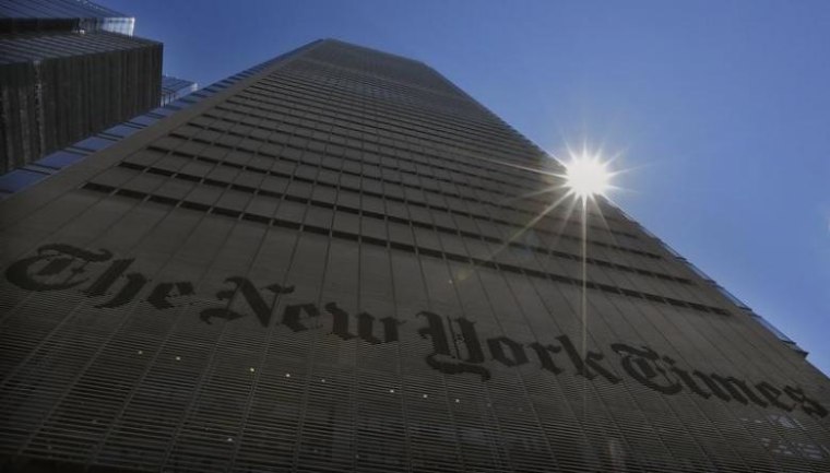 The sun peaks over the New York Times Building in New York