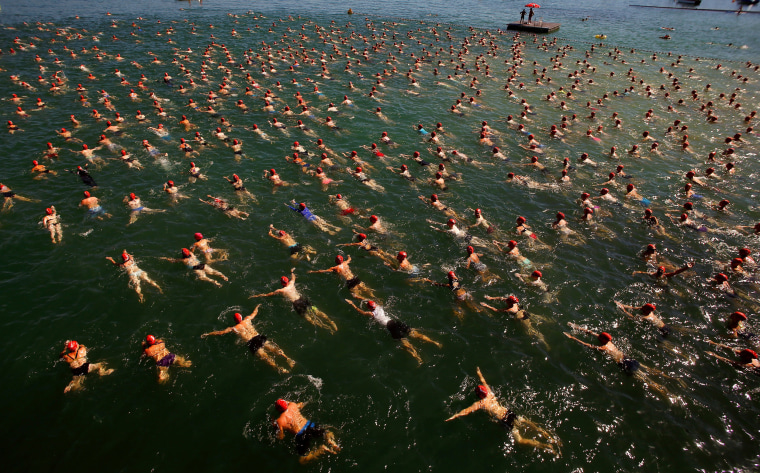 Image: People swim during the annual public Lake Zurich crossing swimming event over a distance of 1,500 metres (4,921 ft) in Zurich