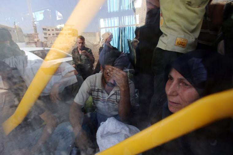 Image: People are seen inside a bus, as they are being evacuated from the town of Daraya