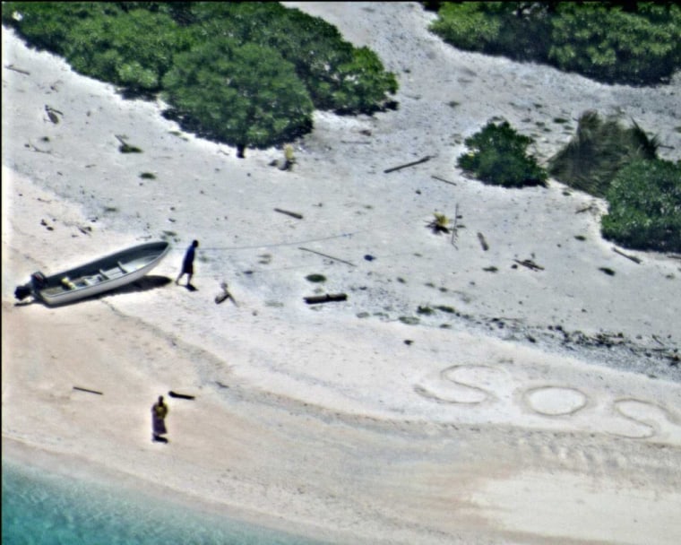 A pair of stranded mariners signal for help by writing "SOS" in the sand.