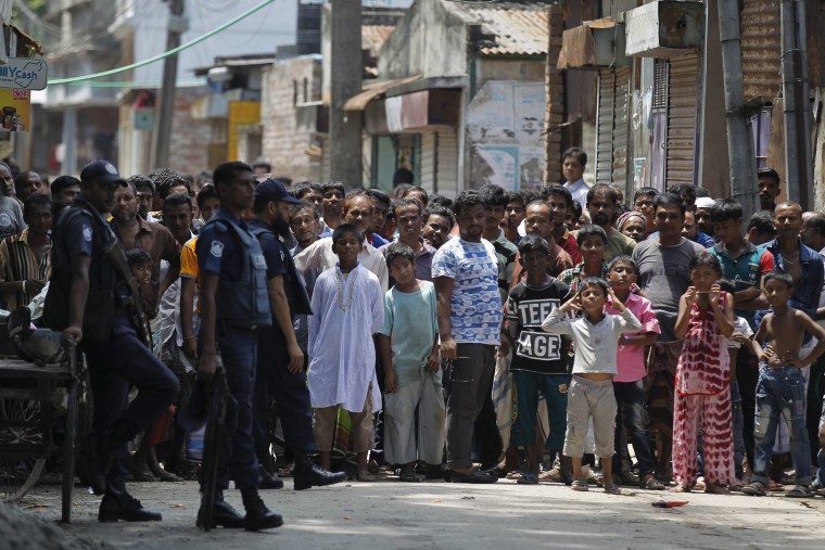 Image: Onlookers gather near the scene of the shooting in Narayanganj, Bangladesh.