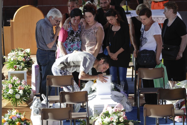 Image: Relatives mourn over a coffin of one of the earthquake victims