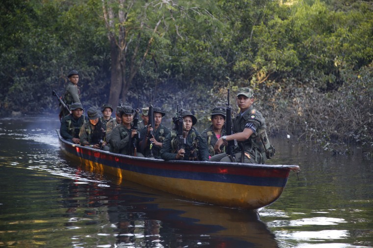 In this Aug. 15, 2016 photo, rebels of the 32nd Front of the Revolutionary Armed Forces of Colombia, or FARC, sit in a boat as they patrol the Mecaya river in the southern jungles of Putumayo, Colombia.