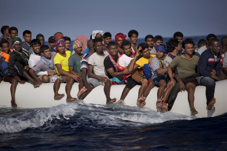 Image: Migrants and refugees flee Libya on board a dinghy