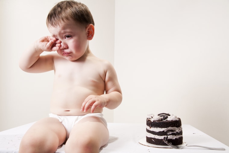 Chubby baby crying over cake