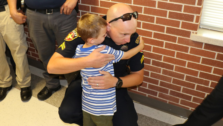 police officers surprising the children of an officer who died by walking them to the first day of school